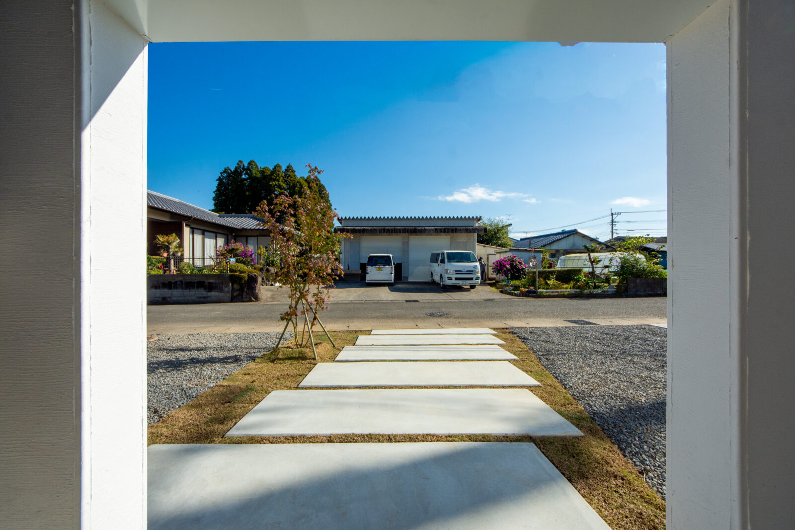 空と緑を切り取る美しい白壁の平屋。光と心地よい余白に包まれて暮らす住まい 写真