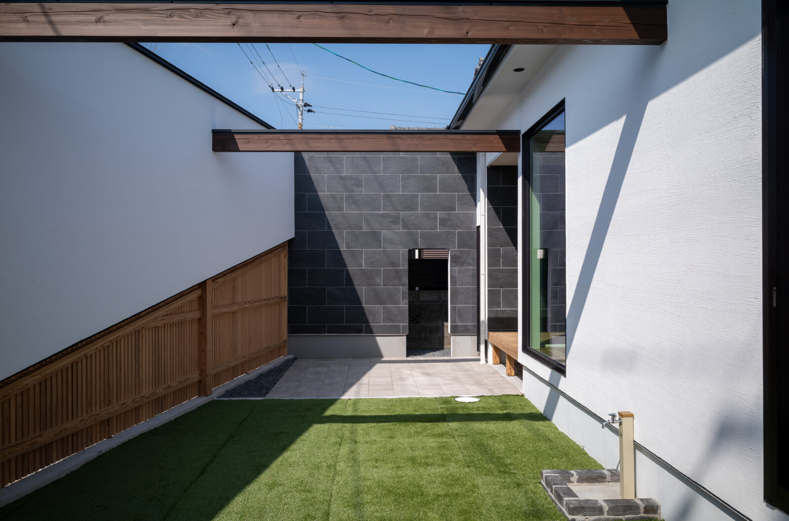 街の喧騒を美しく遮るコートハウス。光と緑に包まれるカーテンレスの平屋 写真