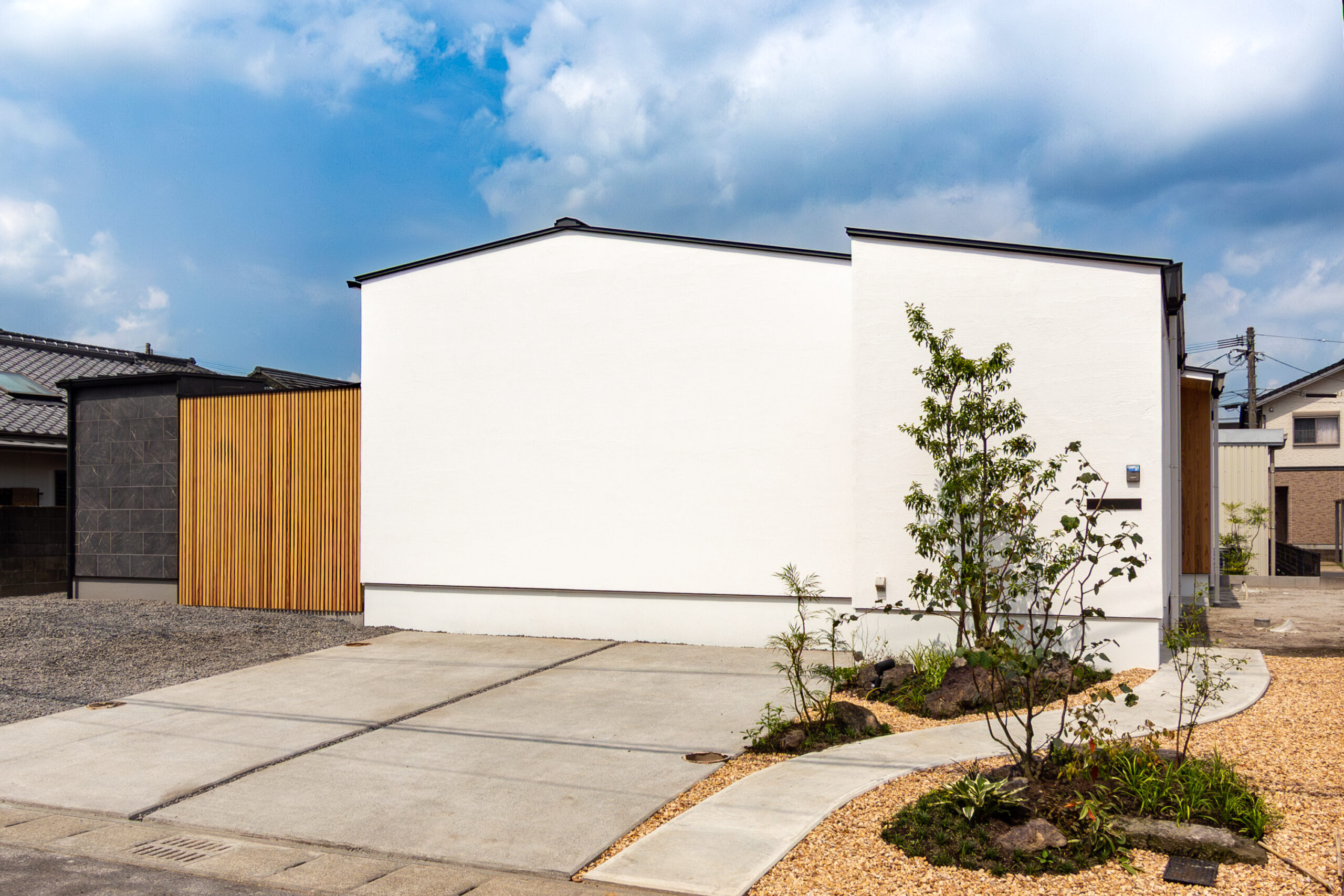 漆喰と無垢材に包まれる余白の空間。空に開かれた三角形のコートハウス